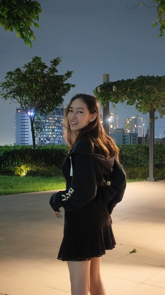 amy smiling in a rooftop garden at night